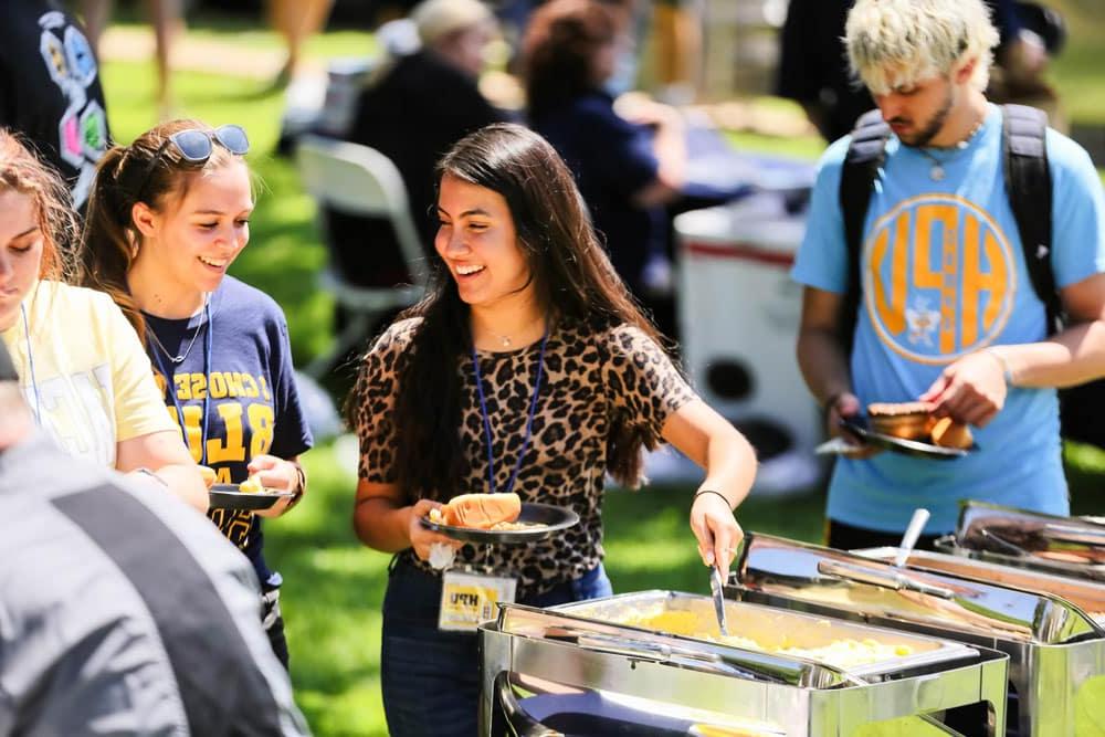 Students serving themselves food at an outdoor Howard Payne University event. | HPU